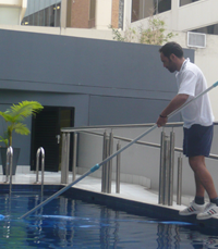 Blu Pool technician cleaning a swimming pool